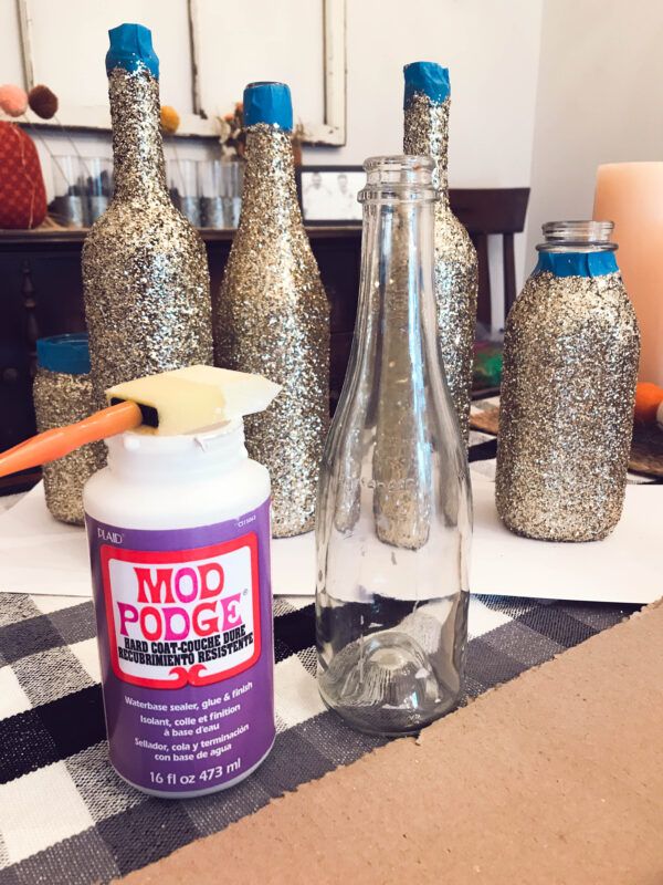 there is a bottle and some glitter bottles on the table