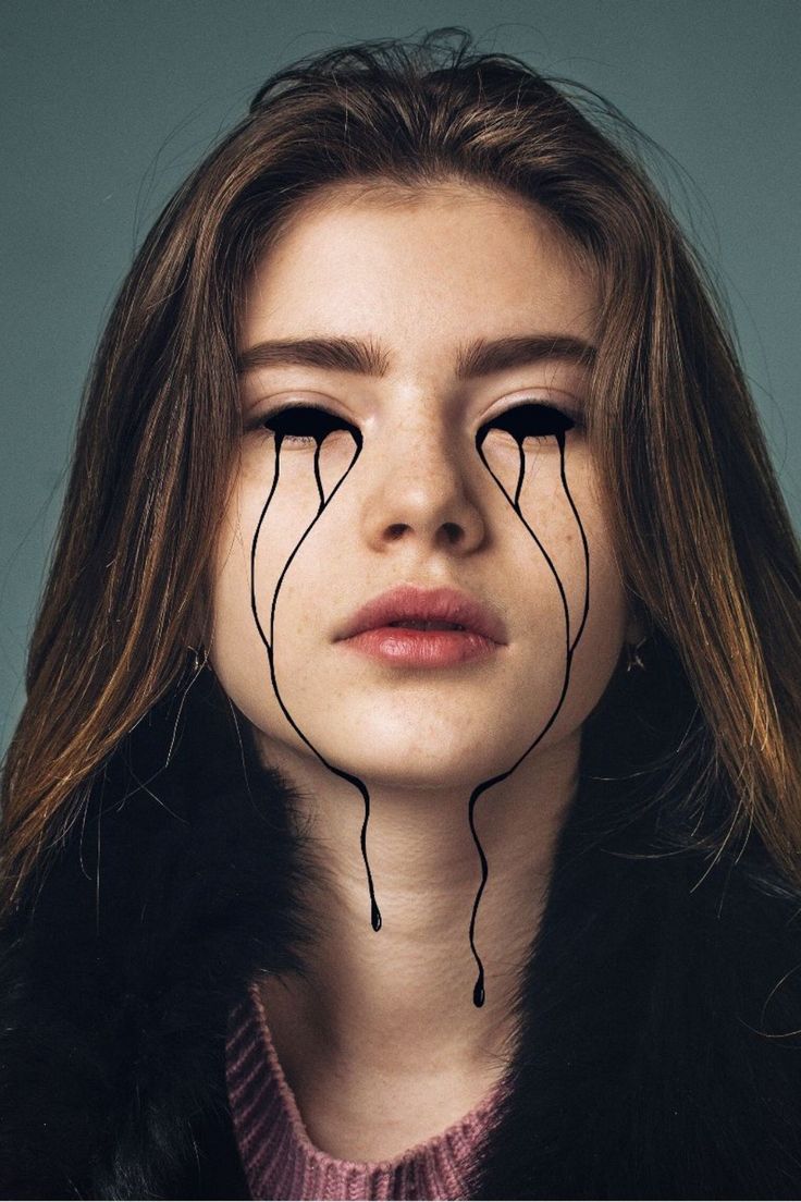 a woman with long hair and black lines on her face