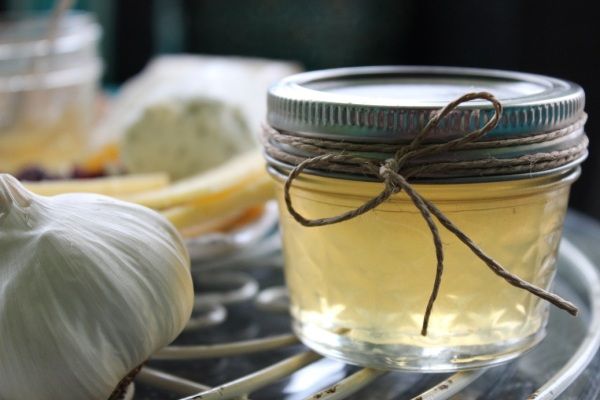 garlic, lemon and garlic oil are sitting on a glass tray with some garlic in the background