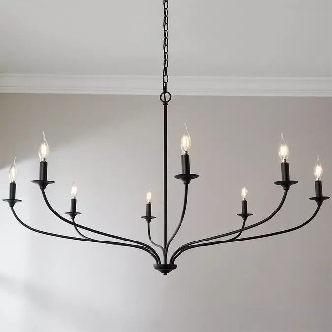 a black chandelier with six candles hanging from it's center, in a room