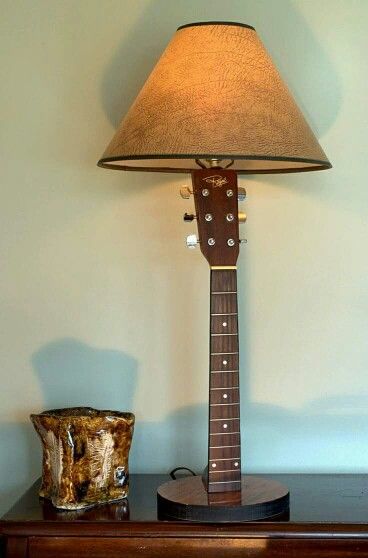 a guitar lamp sitting on top of a wooden table