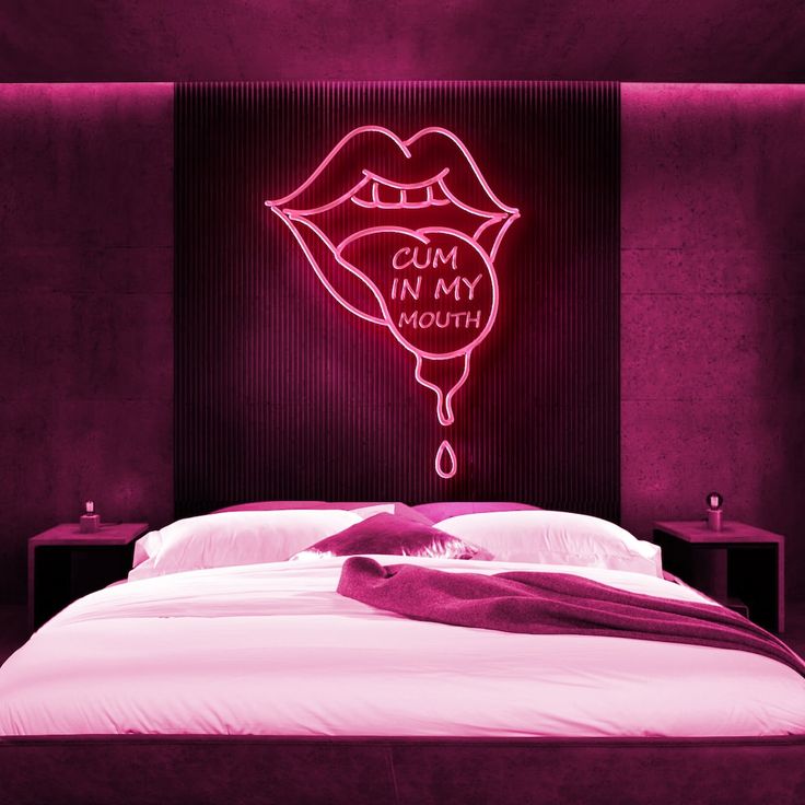 a pink neon sign that says cum in my mouth on the wall above a bed