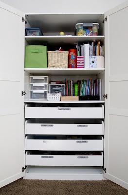 an organized closet with white drawers and shelves