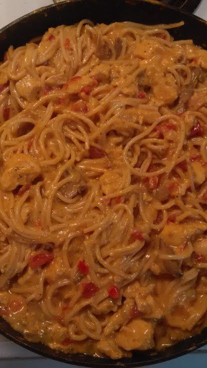 a skillet filled with noodles and sauce on top of a stove