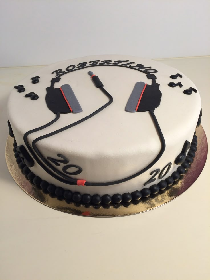 a white cake with black and red designs on it that has ear buds attached to the side