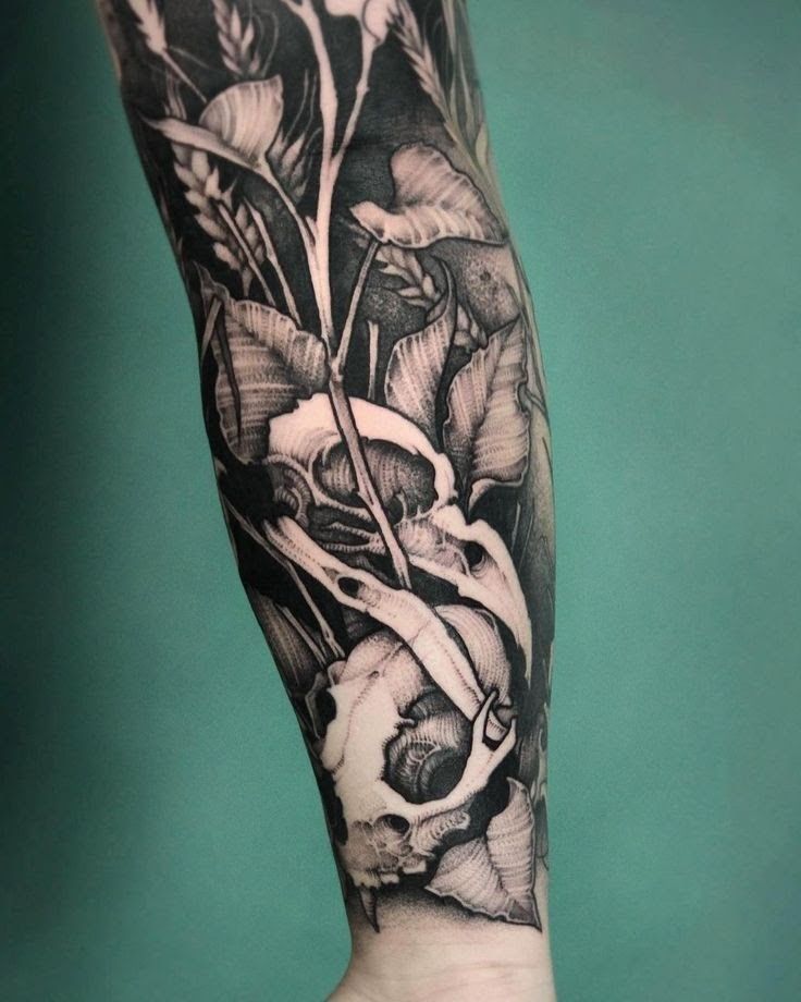 a black and white flower tattoo on the right arm, with an arrow in the middle