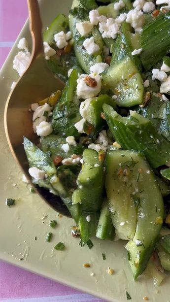 a salad with cucumbers, feta cheese and herbs