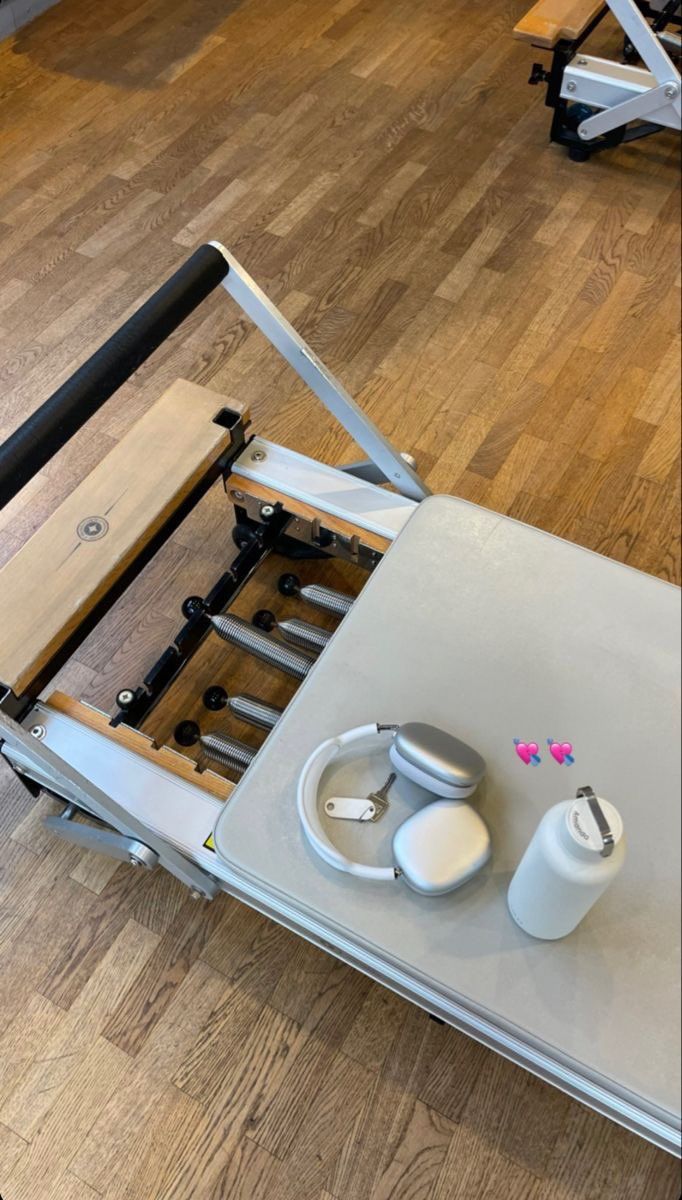 a machine that is sitting on top of a wooden floor next to some bottles and cups