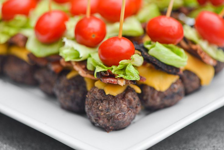 an appetizer with cheese, lettuce and tomatoes on it is sitting on a white plate