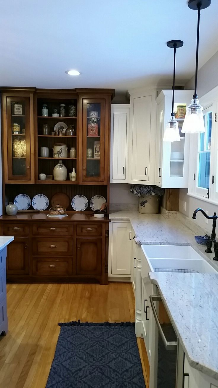 a kitchen with white cabinets and wooden floors