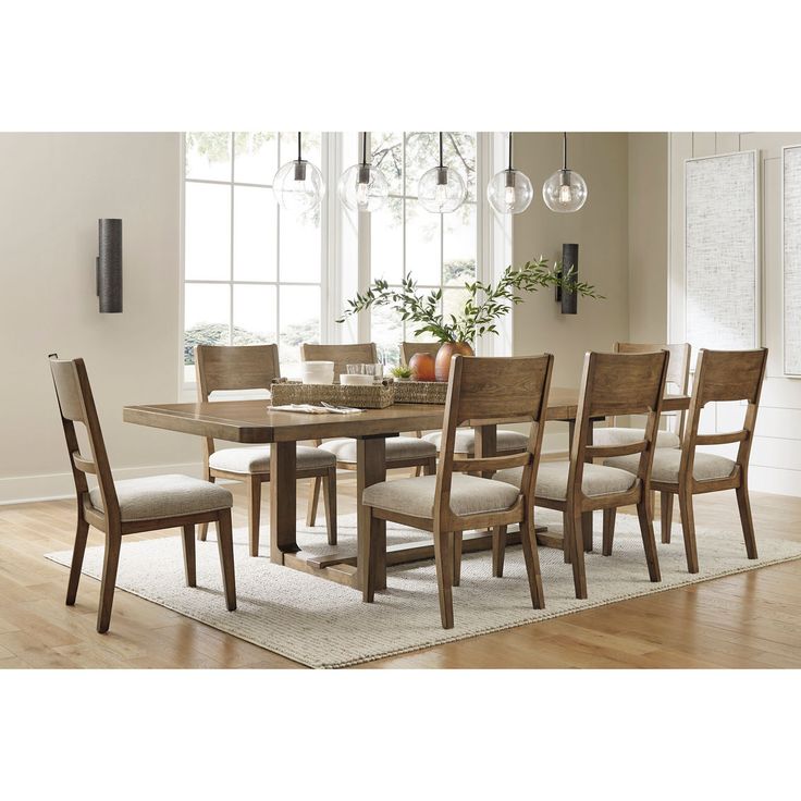 a dining room table with six chairs and a rug on the floor in front of it