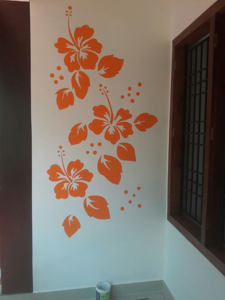 an orange flower painted on the side of a white wall next to a sink and window