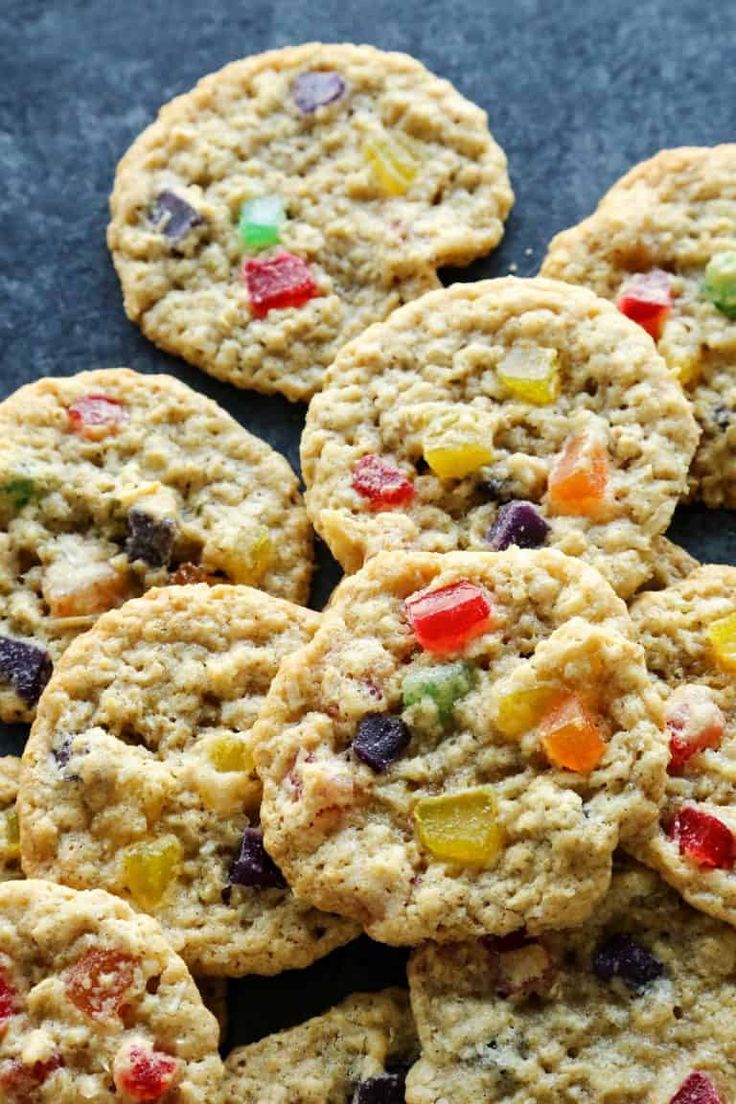 cookies with m & m's and jelly beans are arranged on a black surface