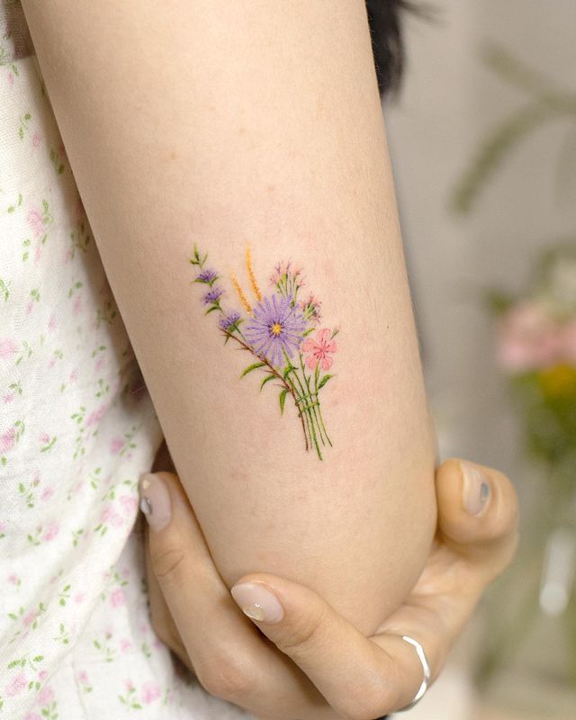 a woman's arm with flowers tattooed on it