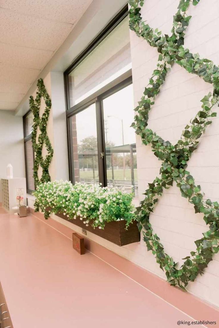 an office building with plants growing on the wall and window sill in front of it