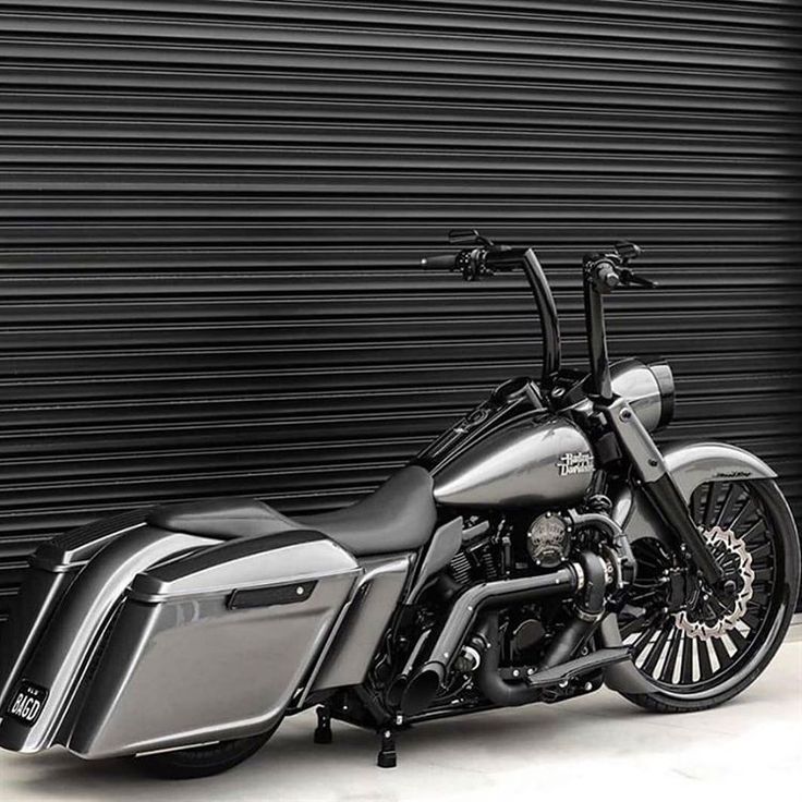 a black and silver motorcycle parked in front of a garage door