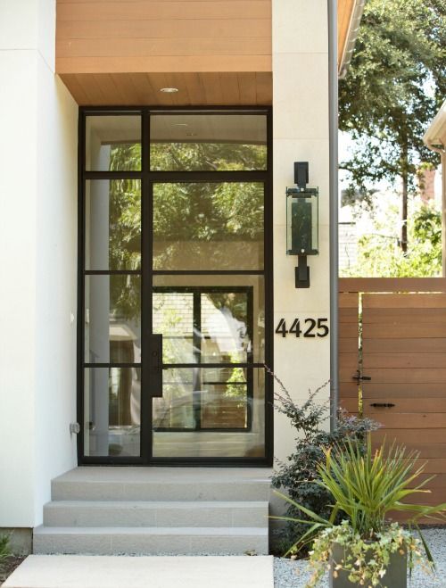 the front door of a house with two plants