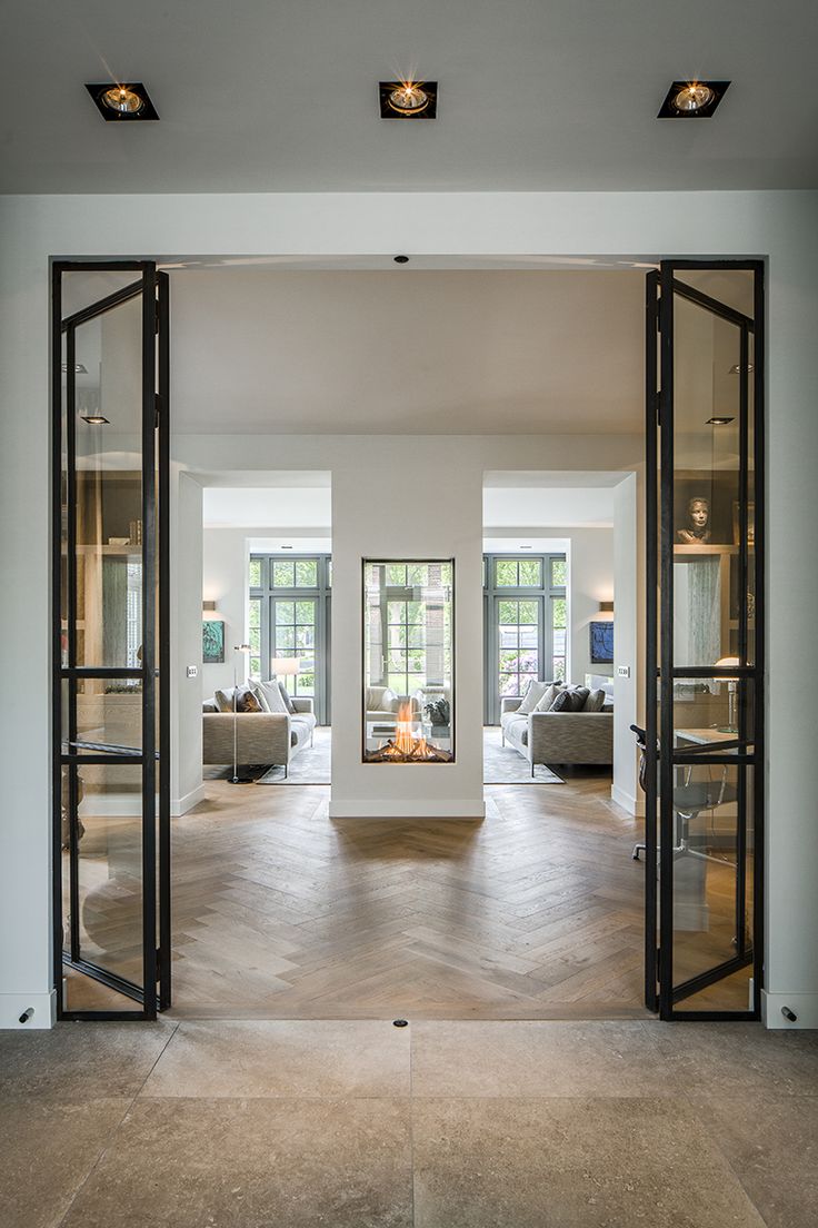 an open living room with glass doors leading to the outside