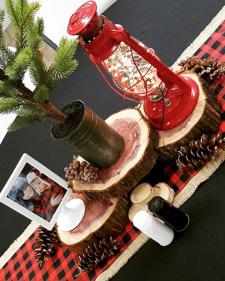 a red phone sitting on top of a tree stump with pine cones and other decorations around it