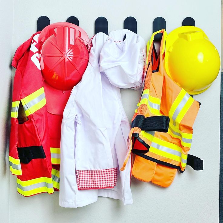 fireman's gear hanging on the wall next to an orange ball and helmet