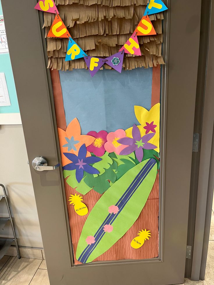 a door decorated with paper flowers and a surfboard on the front entrance to a classroom