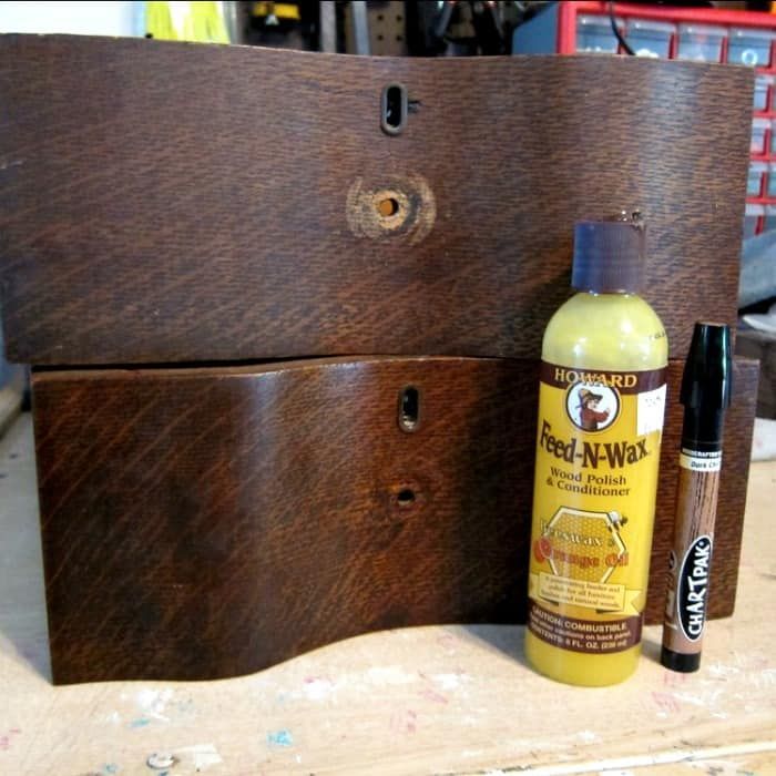 a bottle of wax next to a wooden box with some glue on it and a pen