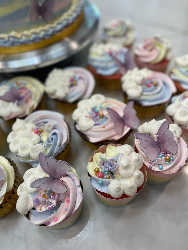 some cupcakes with frosting and decorations on them are sitting on a table