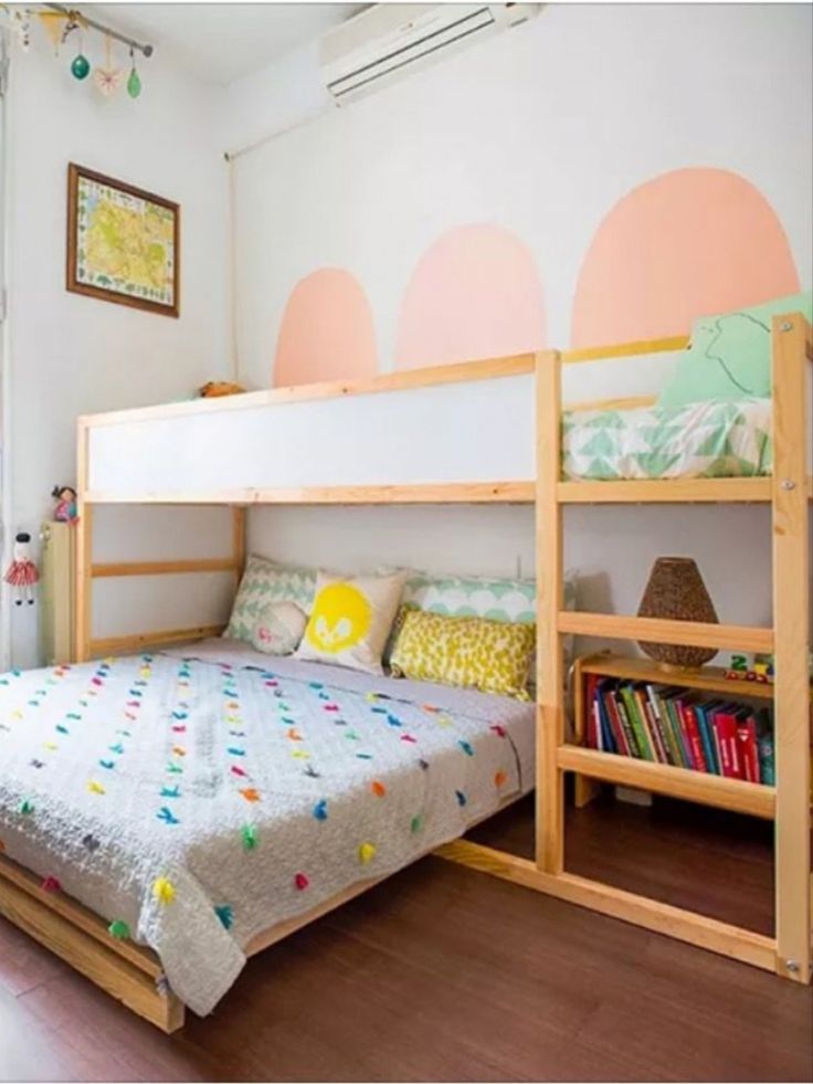 a bunk bed sitting in the middle of a bedroom next to a book shelf filled with books