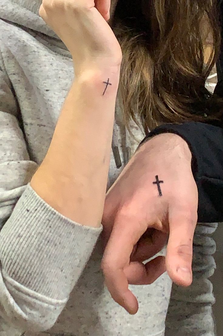 a woman with a cross tattoo on her wrist