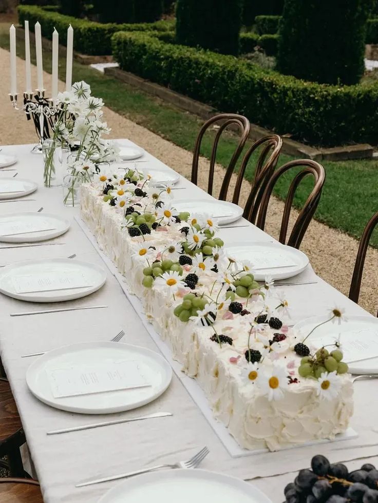 a long table with plates and flowers on it