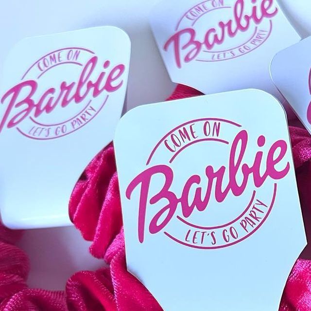 some pink and white paper tags with the word barbie on them