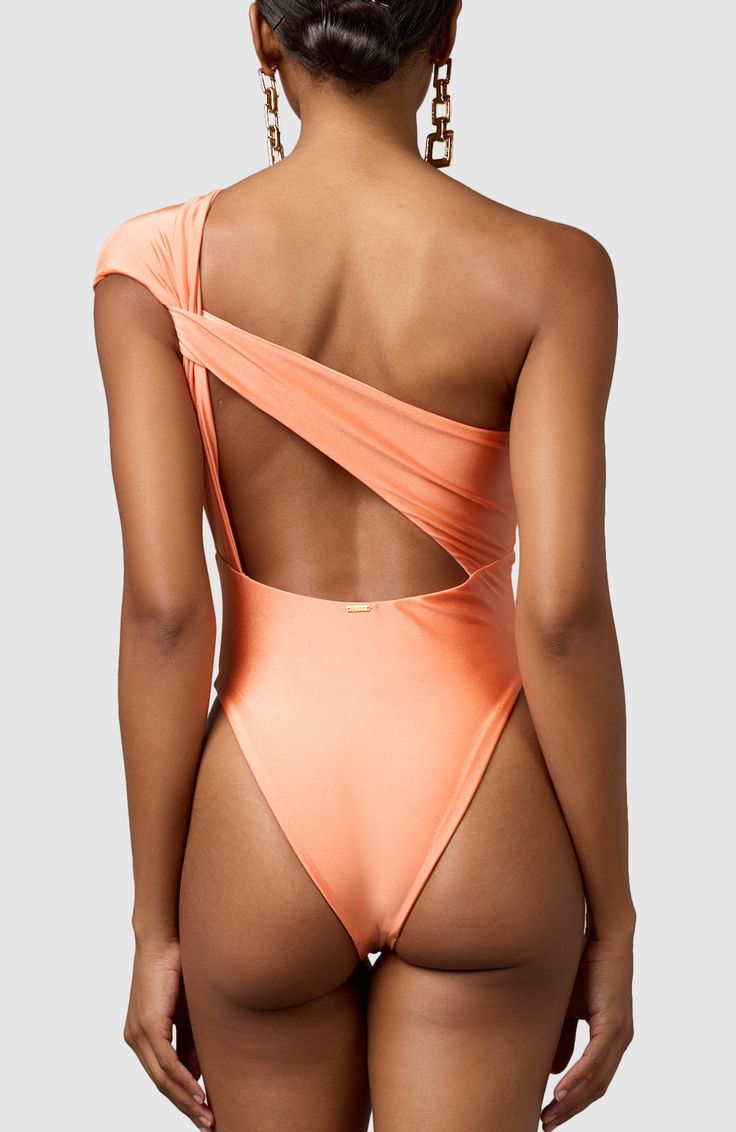 This stunning one piece swimsuit will have you feeling effortlessly classy. It elegantly caps one shoulder and drapes in the back to create a stunning asymmetrical look that will not disappoint. Thick double-lined fabric High cut at legs Cheeky bottoms One Shoulder Bodysuit For Poolside, One-shoulder Bodysuit For Poolside, One-shoulder Swimwear For Party, One Shoulder Beach Party Swimwear, Solid One-shoulder Swimwear For Party, Fitted One-shoulder Swimsuit For Pool, Elegant Swimwear With Asymmetrical Neckline, One Shoulder Solid Color Party Swimwear, Stretch One Shoulder Bodysuit For Beachwear