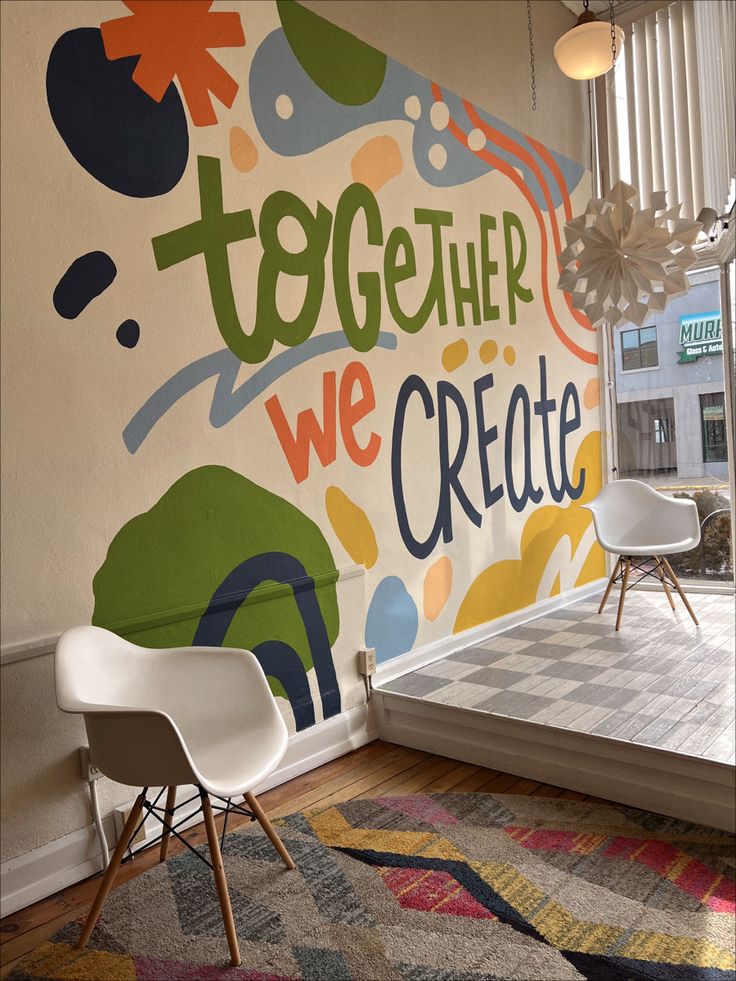 a room with a large mural on the wall that says together we create