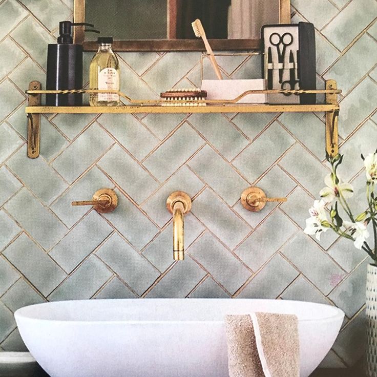 a white bath tub sitting under a bathroom mirror