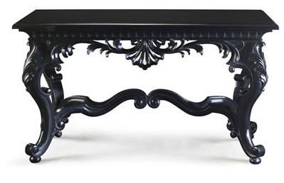 a black table with ornate carvings on the top and bottom, against a white background