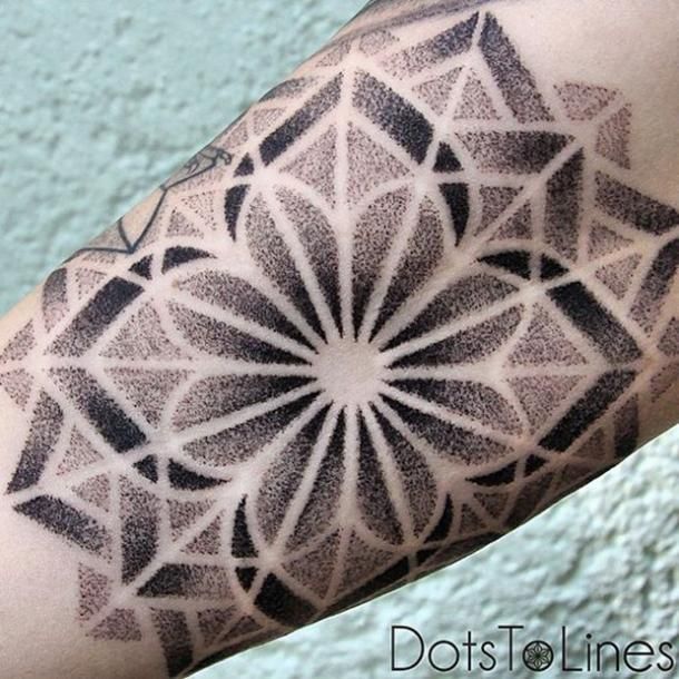 a black and white photo of a tattoo on someone's arm with geometric designs