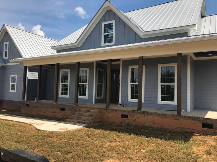 a house with blue siding and white trim on the front door, windows, and porch