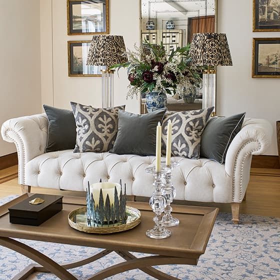 a living room with white couches and blue rugs on the hardwood flooring