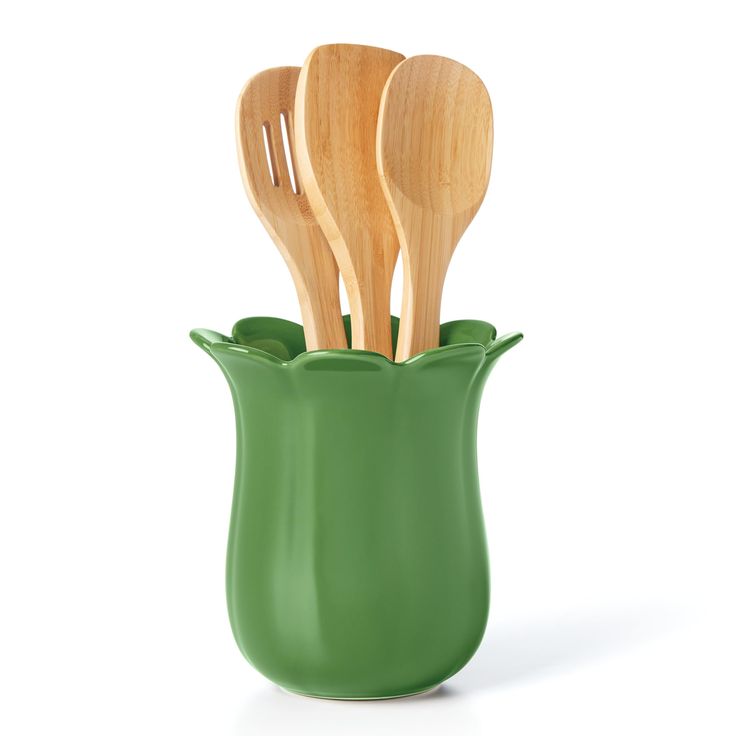 three wooden utensils in a green vase with spoons sticking out of it