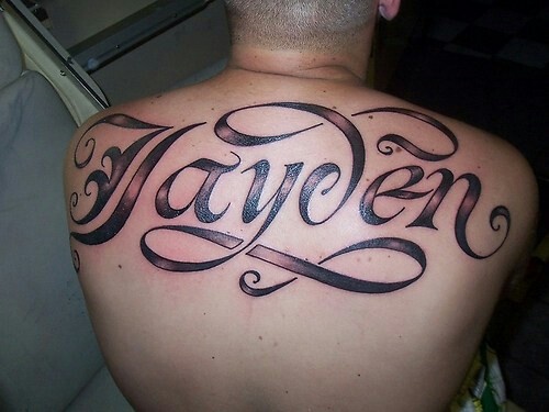 a man with a tattoo on his back has the word heaven written in cursive font