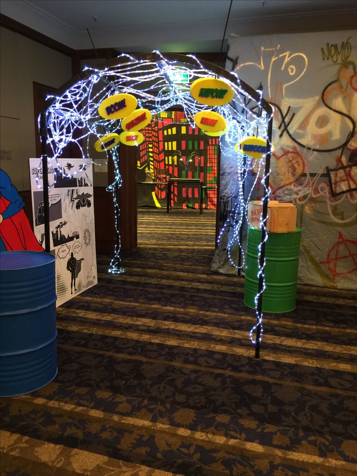 a hallway decorated with lights and decorations for the entrance to an office building that has graffiti on the walls