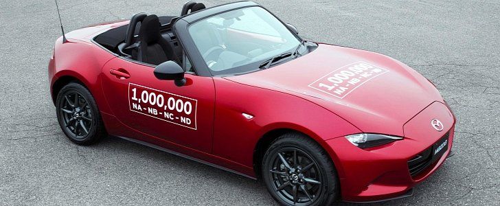 a red mazda roadster parked in a parking lot