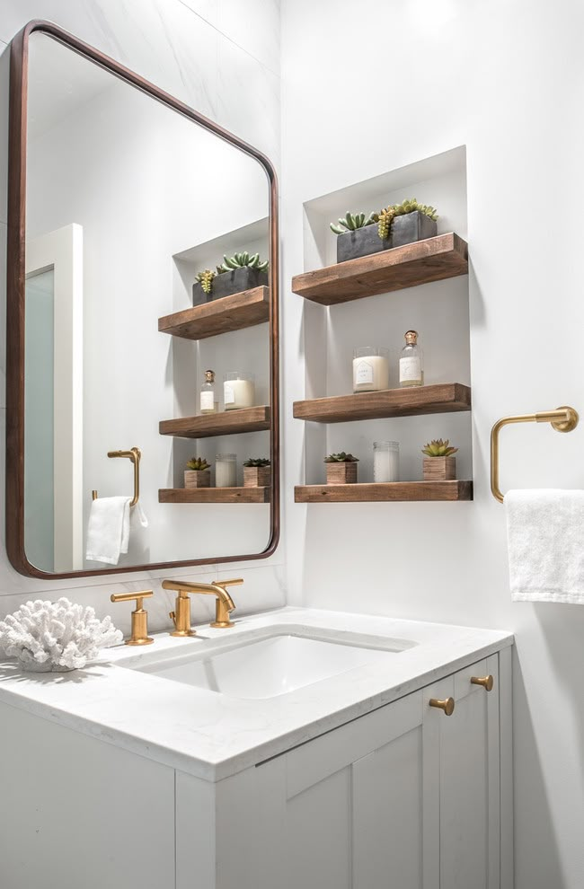 a bathroom sink with two wooden shelves above it and a large mirror on the wall