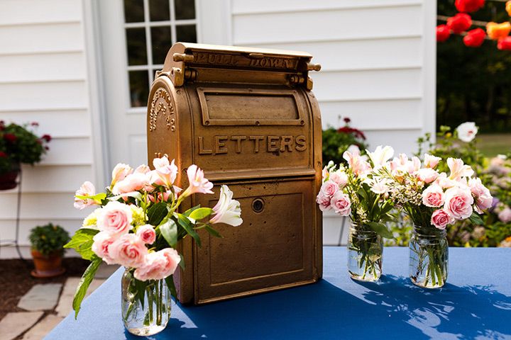 three vases filled with flowers sitting on top of a blue table next to a mailbox