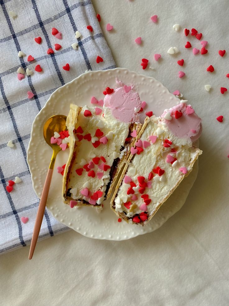 a white plate topped with two slices of cake and sprinkles next to a spoon