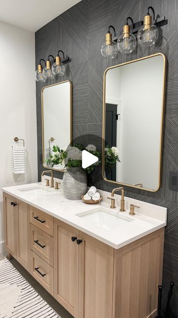 a bathroom with two sinks, mirrors and lights on the wall above them is decorated in black and white