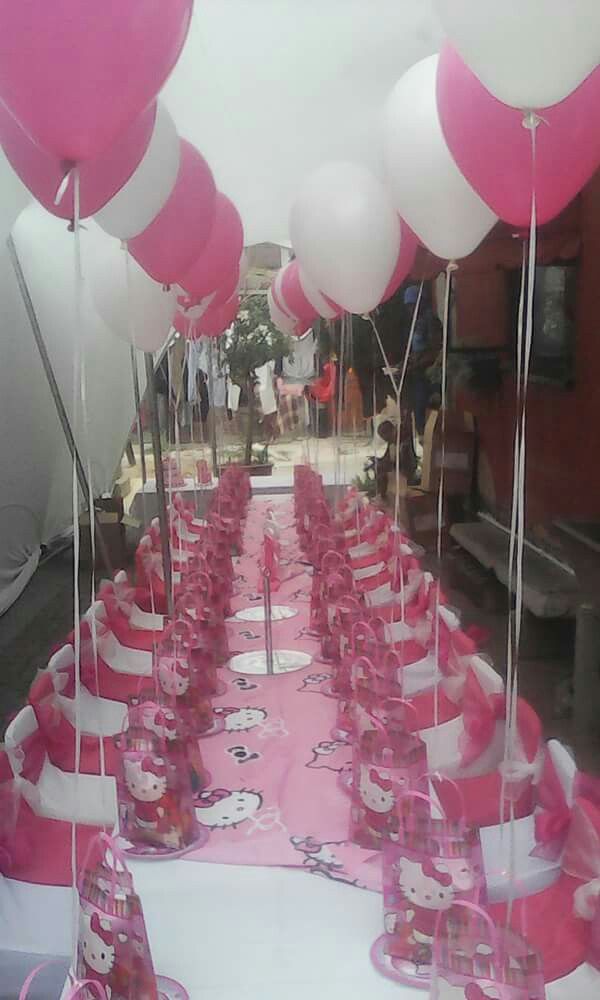 pink and white balloons are on the table at a hello kitty themed birthday party,