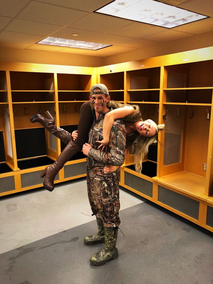 a man holding a woman in an empty locker room with yellow shelving behind him