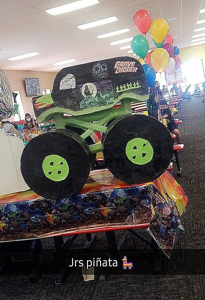 there is a large monster truck made out of tires on display in the store with balloons