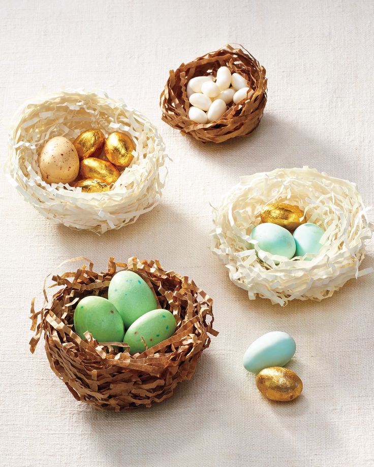 three small nests filled with eggs sitting on top of a table